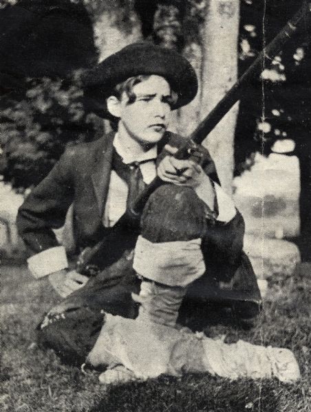 A young Alfred Lunt dressed as Rip Van Winkle, using clothing and a musket borrowed from farm hands and leggings made of gunny sacks.