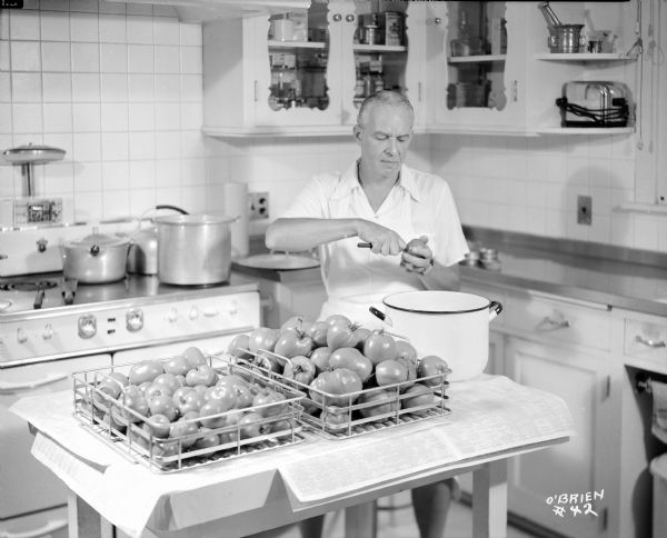 Alfred Lunt coring tomatoes in the kitchen at Ten Chimneys.