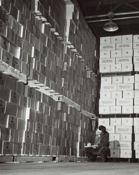 Man taking inventory of Food Crusade packages in the CARE Warehouse.