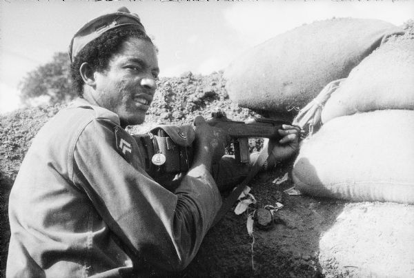A soldier in Castro's forces at the battle for the village of LaMaya, Cuba. He is firing from a position known as "The Hole."