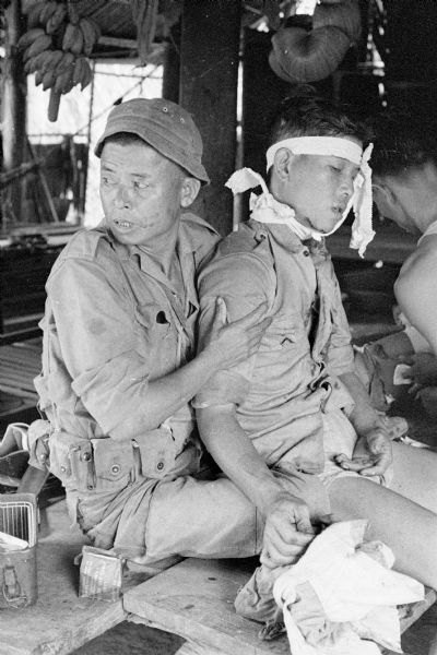 Soldier assisting a wounded South Vietnamese soldier.