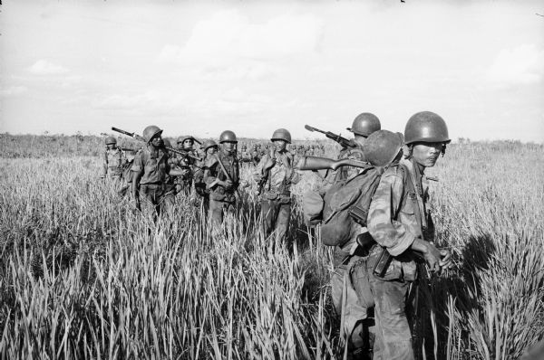 South Vietnamese soldiers pause during a speed march through a rice field.