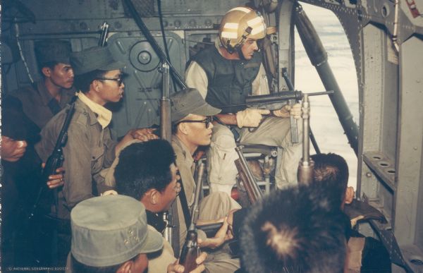 Marine crew chief Nelson West and several South Vietnamese soldiers patrol an area near Vinh Quoi from a helicopter.