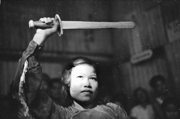 A girl holds a sword over her head while performing a traditional sword dance at the village of Binh Hung, Vietnam.