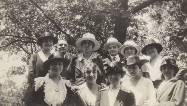 Group portrait of nine women and two men at Lake Geneva. Trees are in the background.