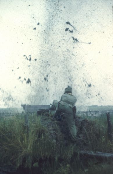 An explosive is detonated by an instructor between rows of crawling Vietnamese Sea Swallow trainees at Binh Hung. The training was intended to teach them that they could survive shelling.