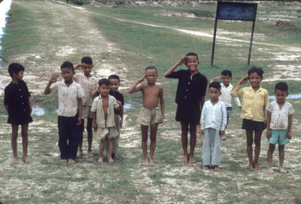 A group of children in a village near the Laotian border saluting a U.S. helicopter that landed there.