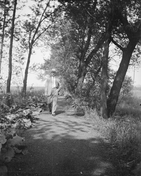 Dr. Joseph Smith strolling down a path with his hand in his left pocket.