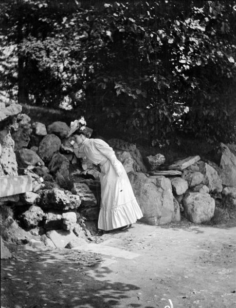 Mary E. Smith taking a drink near some rocks in Garfield Park.