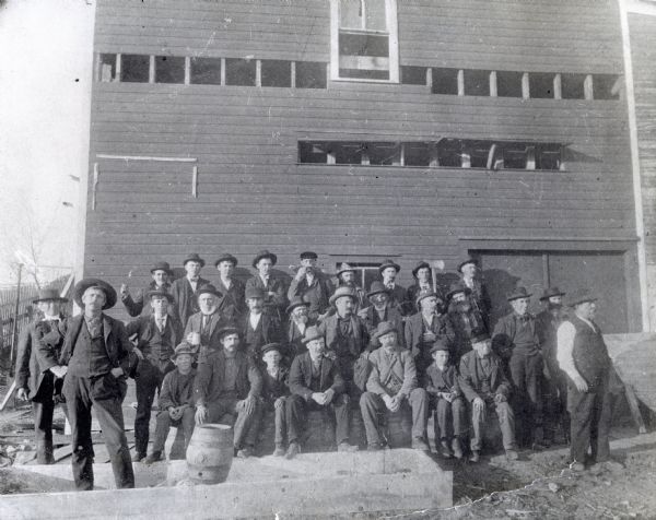 Outdoor group portrait of a crowd visiting Greenwood Brewery. Individuals pictured include: First row, left to right: Anton Novy, Edward McDonough, Frank Rott, Edward Stanek, Jack Rice, August Schulz, Edward Kuchera, Barney Tienery, and Jospeh Bulin (the owner of the brewery); Second row, left to right: Martin Bulin, Frank Housner, John Novy, Robert Ferguson, Frank Novy, Joseph Houner, Vaclav Pacl, John Bulin, Frank Novy, Joseph Kuchera, and Joseph Novy; Back row, left to right: Joseph Landsinger, James Plachet, Joseph Novy, Frank Novy, Michael Novy, Charles Ferguson, James Bruha, Fred Subera, and James Pacl.