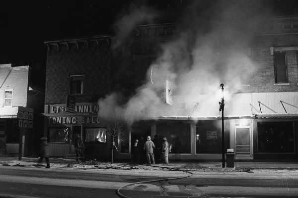 Firefighters battle a fire that engulfed Kruk's Drug Store and Hansen's Department Store. The pharmacy was to change ownership the next day.