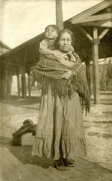 Portrait of Josh Sanford as a child with his mother, Maude Decorah. Sanford served in the Army Air Corps during WWII and is credited with being the only Native American pilot to serve in China. Sanford eventually reached the rank of Captain, won the Fly Cross Award, and took part in at least 74 combat missions. Sanford's mother was a member of the Winnebago Tribe while Sanford's father was a member of the Seneca Tribe.