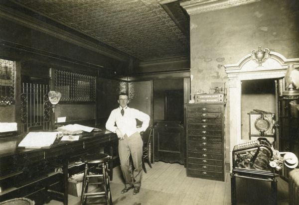 Interior view of the Hillsboro State Bank, which was open from 1902 to 1932 when it merged with Farmer's State Bank. The man leaning on the counter is thought to be Henry Kaufman.