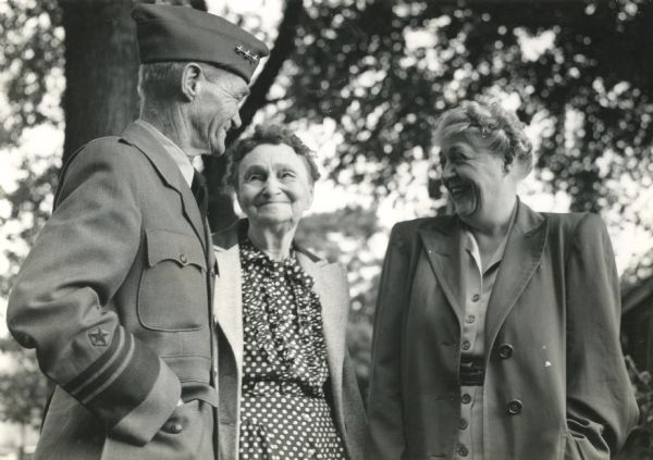 Vice-Admiral Marc A. Mitscher, a Hillsboro native, in conversation with his mother, Mrs. Myrta Mitscher (left), and his wife, Frances Smalley Mitscher, after a reunion at his birthplace, the first time he had visited Hillsboro in a decade. Hillsburo celebrated Mitscher's visit with a parade and party. Local and state newspapers covered the event.