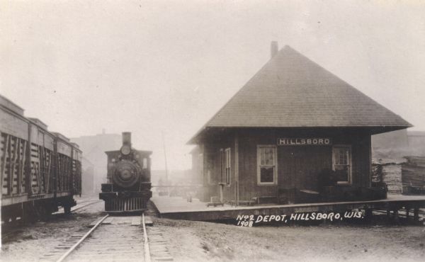 View down railroad tracks towards a locomotive at the Hillsboro Train Depot. The Hillsboro and Northeastern Railroad was built in 1903 and was a short track connecting Hillsboro with Union Center. The railroad ceased operation in the late 1960's.