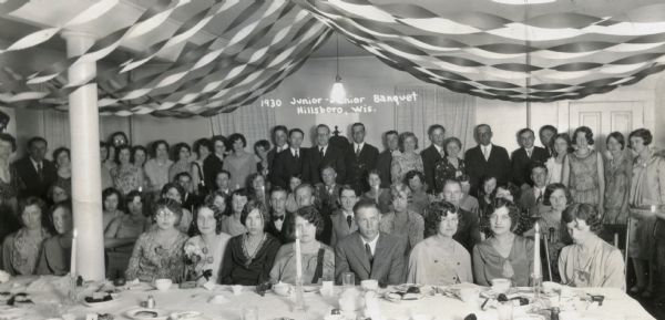Group portrait of attendees of the Hillsboro High School's Junior-Senior Banquet at the Hillsboro Hotel. Attendees include students and their guests. The interior of the banquet hall is decorated with streamers.