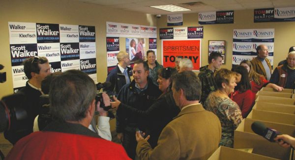National Republican Party Chairman Reince Priebus and La Crosse Operation Homefront Director Patti Lokken being interviewed at a Paul Ryan Rally Event, La Crosse County Republican Headquarters. The walls of the room are covered with Republican campaign posters.