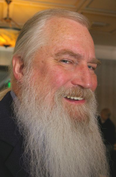 The La Crosse based artist John Satory and his long white beard, in partial profile at the DMI Trend Showcase in the Cargill Room.