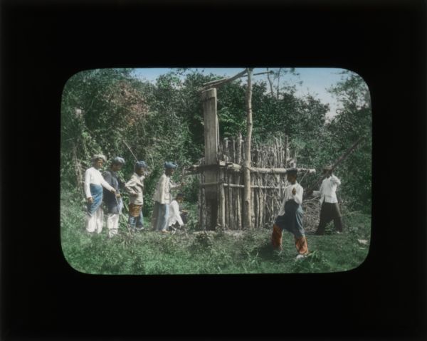 During her visit to Sudan, Carrie describes a tiger hunt. The men of the village built large wooden traps for the tiger, seen here with men posed around it.