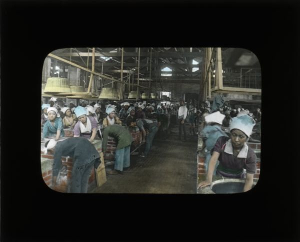 Women working in a textile factory. They are cleaning or dying material. Carrie describes the work at textile factories in her journal from China as crowded and with long hours. She writes how almost any position a women could attain in these factories involved laborious work.