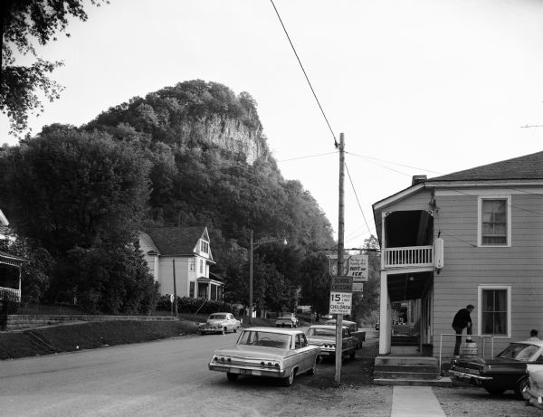 Mississippi River fishing town, bluff in background, looking south from a main street and showing arcade passage through store fronts.