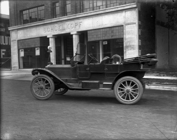 A Maxwell GA touring car is parked in the street in front of the Schoelkopf dealership at 210 East Washington Avenue.