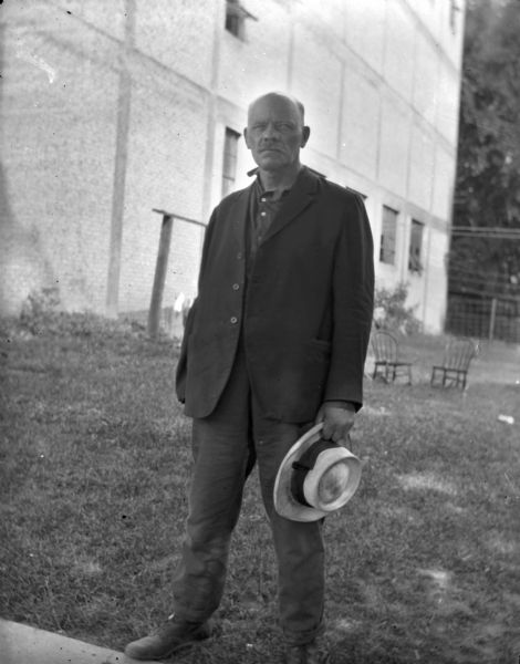 Amund Reindahl, standing outdoors and posing with a hat in his hand, was a friend of Louis Schoelkopf. He was Dane County register of deeds from 1899 to 1903. He donated land for a park in Madison called Reindahl Park.
