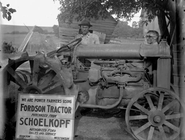 Two men standing behind a tractor in front of a small building on a farm. A sign in front of the tractor reads: "We Are Power Farmers Using Fordson Tractor Purchased from Schoelkopf, Authorized Ford Sales and Service, Madison, Wisconsin."

Fordson tractors were manufactured by the Henry Ford Company from 1916 through the 1930s all over the world, but only made from 1918-1928 in the United States.