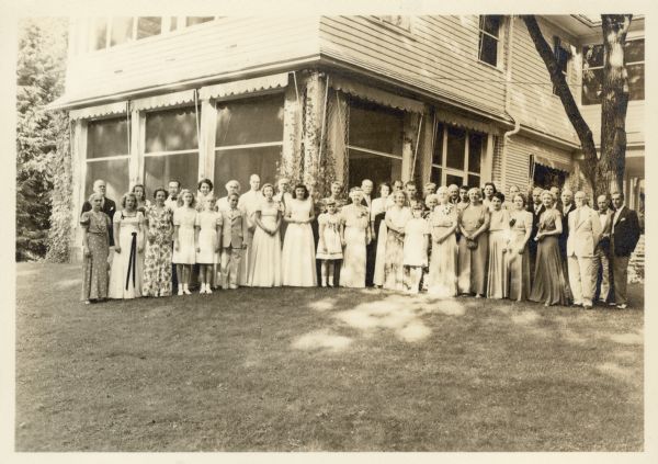 Family members pose on the lawn of the Bartholomay house on the Black Point Estate. They have gathered to celebrate the fiftieth wedding anniversary of Clara Seipp and Henry Bartholomay, Jr., who is standing just to the right of the corner column of the porch. Standing several places to Clara's right are her sisters Elsa Seipp Madlener, with large corsage, and Alma Seipp Hay, just behind Elsa. The three women were daughters of Conrad Seipp, the prominent Chicago brewer who built Black Point.