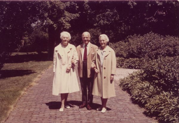 Alma Schmidt Petersen, left, poses with her sister, Clara Theresa (Tessa) Schmidt Reese, and brother-in-law Dr. Hans Reese on the shrub-bordered brick drive at Black Point Estate. Alma and Tessa were granddaughters of Conrad Seipp, Chicago brewer and builder of Black Point. Dr. Reese, a native of Germany and member of Germany's 1912 Olympic soccer team, was chairman of the Department of Neuropsychiatry at the University of Wisconsin until 1956.