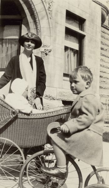 Alma Schmidt Petersen poses with her sons, Conrad, in baby buggy, and Edward, on tricycle, in front of their home at 1322 North Astor Street, in Chicago's Gold Coast neighborhood. Alma was the granddaughter of Chicago brewer Conrad Seipp and an owner of Black Point Estate, the family's summer home.