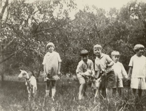 Five children, probably cousins, including Edward Petersen, center, and his brother Conrad, second from right, pose with two goats in an orchard at Black Point Estate. The children cared for the goats during the summers they spent on the estate.