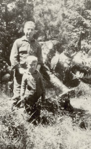 Dr. William F. Petersen, with his son Edward, poses next to a dragon that he created for his sons at Black Point Estate.