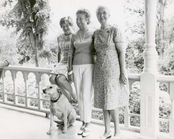 Left to right, Zika Bakieff Petersen, Gladys Zimmerman, and Alma Schmidt Petersen pose with the dog, Bamboo, on the porch at Black Point Estate. The three women, with other members of the Lake Geneva Garden Club, served as hostesses for a tour of Lake Geneva for members of the local press. The tour included a noon luncheon at Black Point Estate. Zika Petersen was the wife of Alma's son Edward.