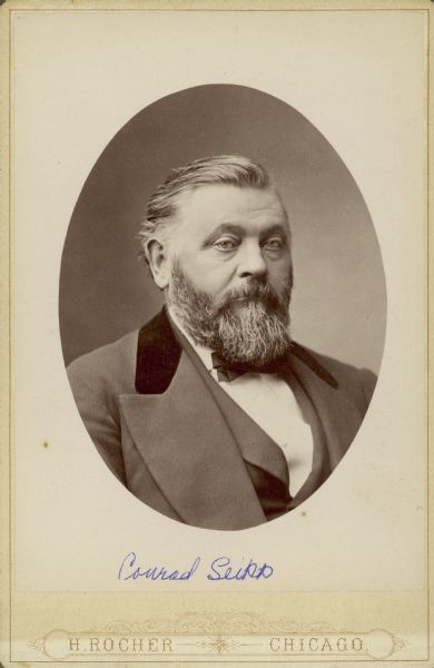 Oval-framed quarter-length portrait of Chicago brewer Conrad Seipp (1825-1890).  He is wearing a suit and vest with bow tie. The collar of the suit coat has velvet trim. Seipp established Black Point Estate in 1888.