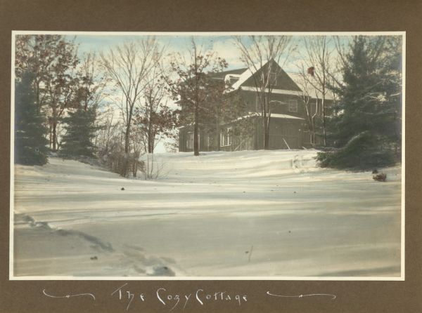The large, wood framed 1905 cottage at Black Point stands at the crest of a gentle snowy slope framed by evergreens and bare deciduous trees. The cottage was built by Mrs. Conrad Seipp to allow her to spend more time in the spring and fall at Black Point Estate, since the main house did not have central heat. After Mrs. Seipp's death in 1920, the cottage was owned by her daughter and son-in-law, Clara and Henry Bartholomay, Jr.