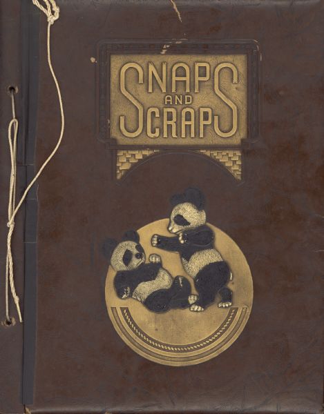 Two pandas "scrap" on the embossed leather cover of a scrapbook bearing the title "Snaps and Scraps." Metallic gold highlights the embossed areas. The scrapbook, kept by Ernst Conrad Schmidt, contains many photographs of yachts competing in regattas sponsored by the Inland Lake Yachting Association. Also included are photographs of Schmidt in his capacity as Commodore of the ILYA.