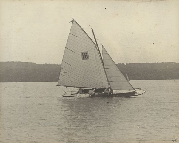 The sailboat "Senta" competes in the Sheridan Prize Race at Geneva Lake. The "Senta" belonged to Dr. Otto L. Schmidt, who is the skipper here. He was an owner of Black Point Estate. Two crew members are also seen. The annual race was established in 1874 to honor Civil War General Philip Sheridan, who was visiting the area. The Geneva Lake Yacht Club (now the Lake Geneva Yacht Club), which sponsors the event, was established the same year.