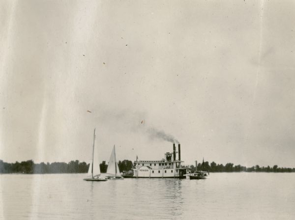 A description of this photograph provided by Ernst Schmidt reads: "The government river inspection boat with the 'Mystery' tied to her and the 'Bottoms Up' near by. The 'Menasha' was a might[y] nice boat." The "Mystery" was a racing yacht owned by the Schmidt family of Black Point Estate. She was competing in the 1927 Inland Lake Yachting Association Regatta on Lake Winnebago. The Menasha was a side wheeled steamboat on the Fox River.