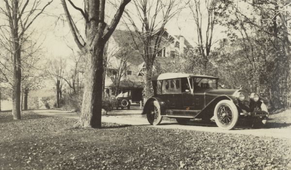 A 1922 Locomobile (foreground) and a 1917 model of the same make are parked near the main house at Black Point Estate. Geneva Lake is in the background.