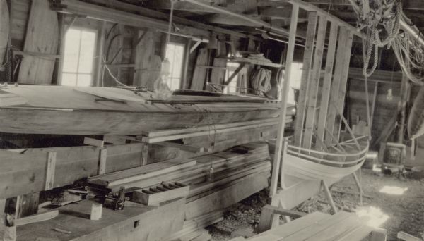 The "Green Dragon" racing yacht, left and a dinghy under construction at John M. Nelson's workshop.