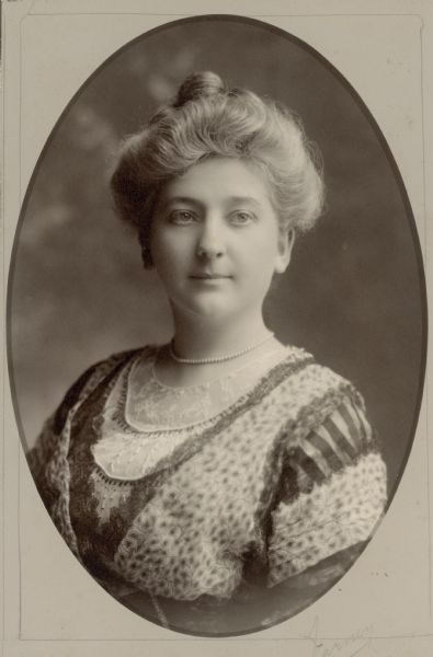 Quarter-length portrait of Clara Seipp Bartholomay, a daughter of Chicago brewer Conrad Seipp. She is wearing a dress with elaborate trim and a pearl necklace.