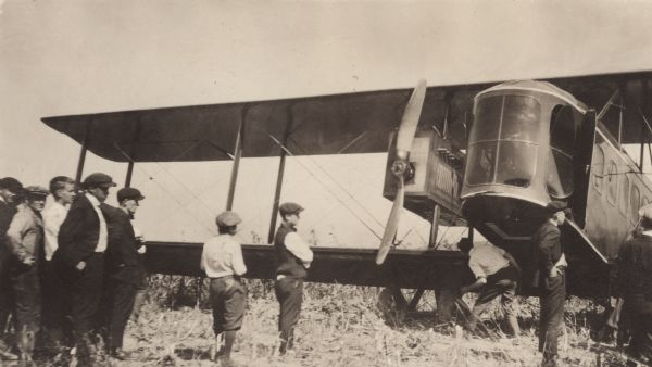 Several boys and young men are standing in the foreground in front of a Lawson Air Liner.