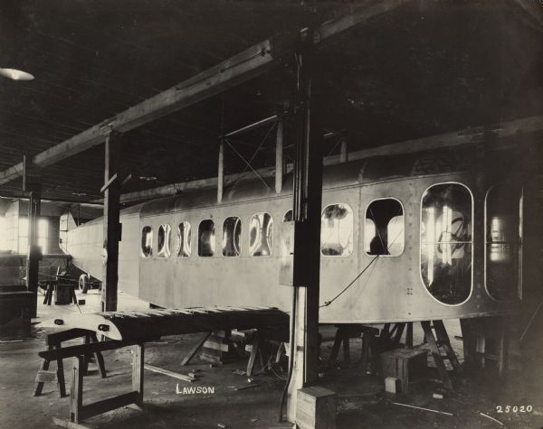 Three-quarter view of the front a Lawson Air Liner after plating and glass have been attached to the cabin and the tail. Part of the wing structure is attached, with ribs exposed.