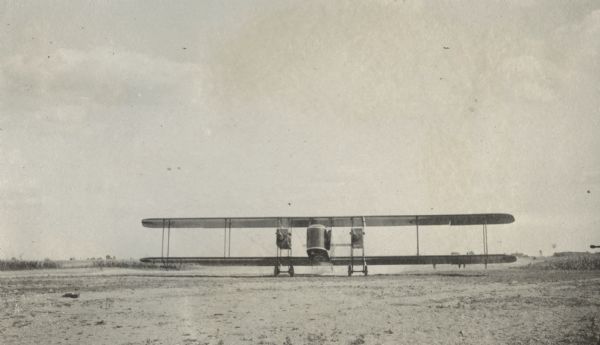 A Lawson Air Liner in a field, with a cloud of dust under the fuselage, suggesting that the plane is in motion.