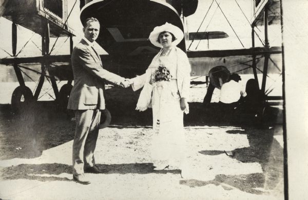 Alfred Lawson shaking hands with a woman, identified elsewhere as "Mrs. John Pfingsten, wife of one of the Lawson company stockholders," who subsequently christens the Lawson Air Liner before its maiden flight.