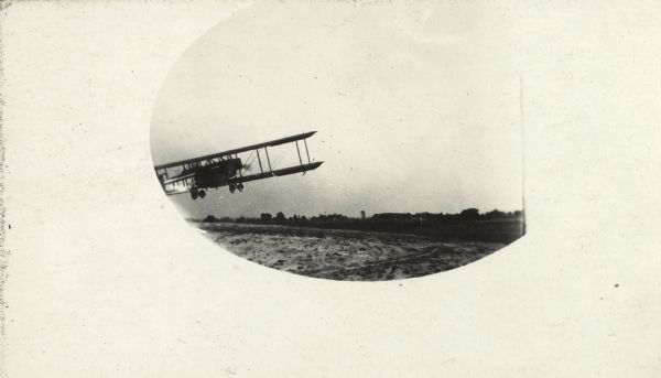 Oval framed image of a Lawson Air Liner taking off from a field.