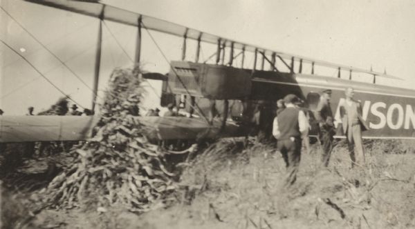 Several people standing in a field near a Lawson Air Liner. The image is out of focus, but Alfred Lawson might be among them.