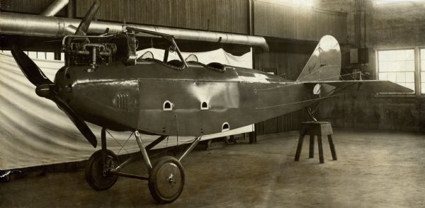 A Lawson Military Tractor 2 (MT2) fuselage in the Lawson plant. The airplane is almost fully assembled, except for the wings, which are not yet attached. The back of the airplane is resting on a support.