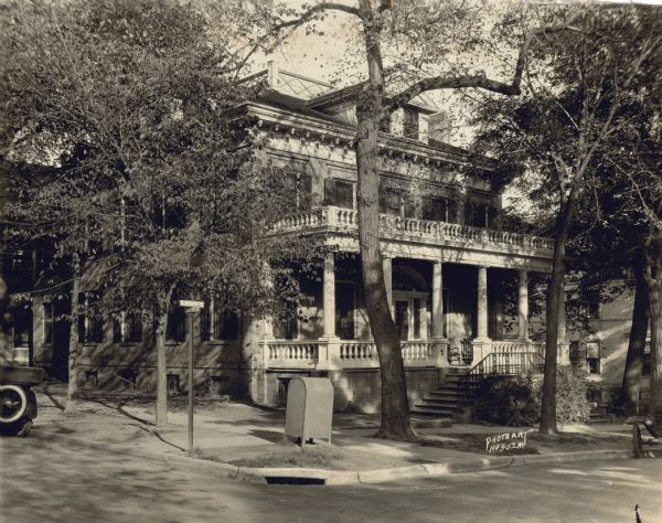 Exterior view from street of the Levi B. Vilas house at 521 North Henry Street, after the porch and steps were remodeled by Arthur O. Fox, brother of Mrs. William F. Vilas, who purchased it from the Vilas family in 1894. Built in 1851 at a cost of $15,000, its location on Lake Mendota ridge was considered to be remote because of its distance north of the Capitol. Vilas died in 1878 and his wife continued to reside in the house until her death in 1892. From 1911 to 1927, the house served as the Phi Gamma Delta fraternity house for the University of Wisconsin. In 1965, the house was demolished to enable the construction of the current Evans Scholars House.